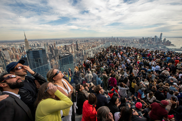 People watch the partial solar eclipse as they gather on the observation deck of Edge at Hudson Yards in New York City, New York, U.S., April 8, 2024. REUTERS/Eduardo Munoz TPX IMAGES OF THE DAY